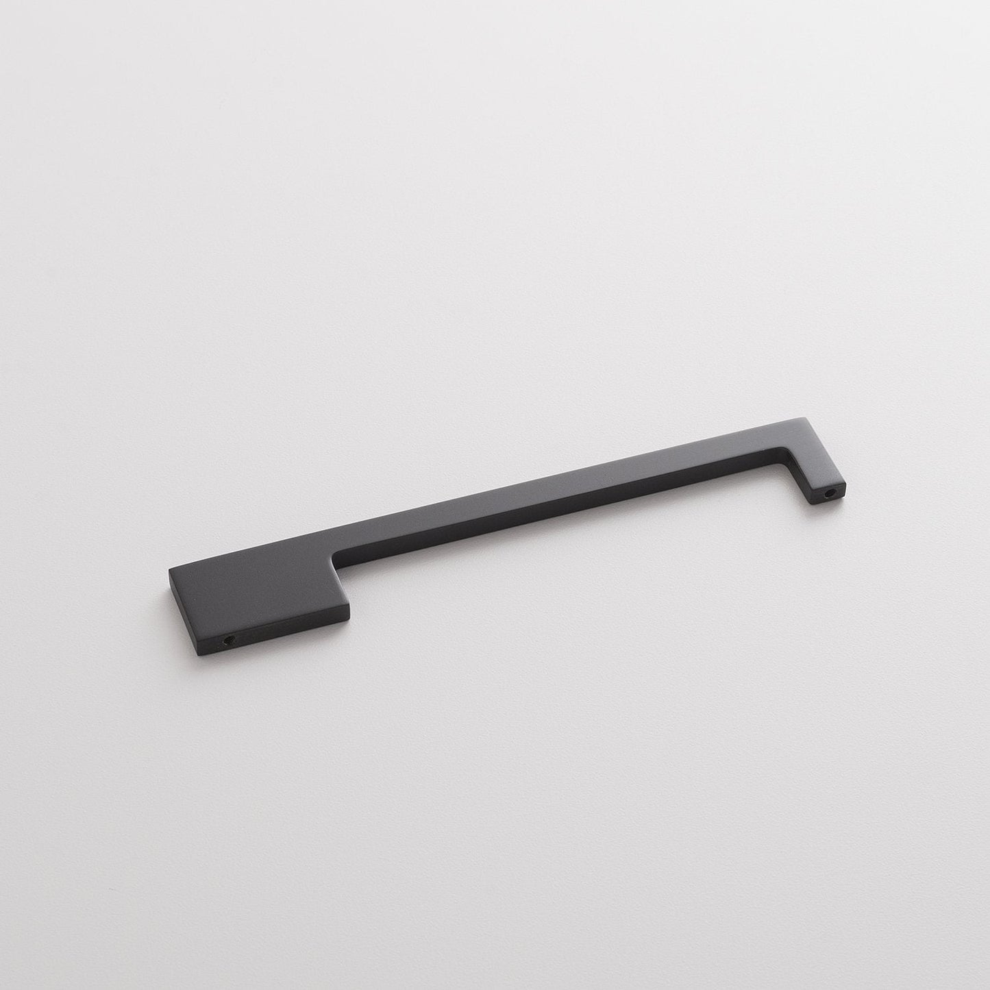 Angled view of Alberta Pull showcasing its thin asymmetrical black design on a white background
