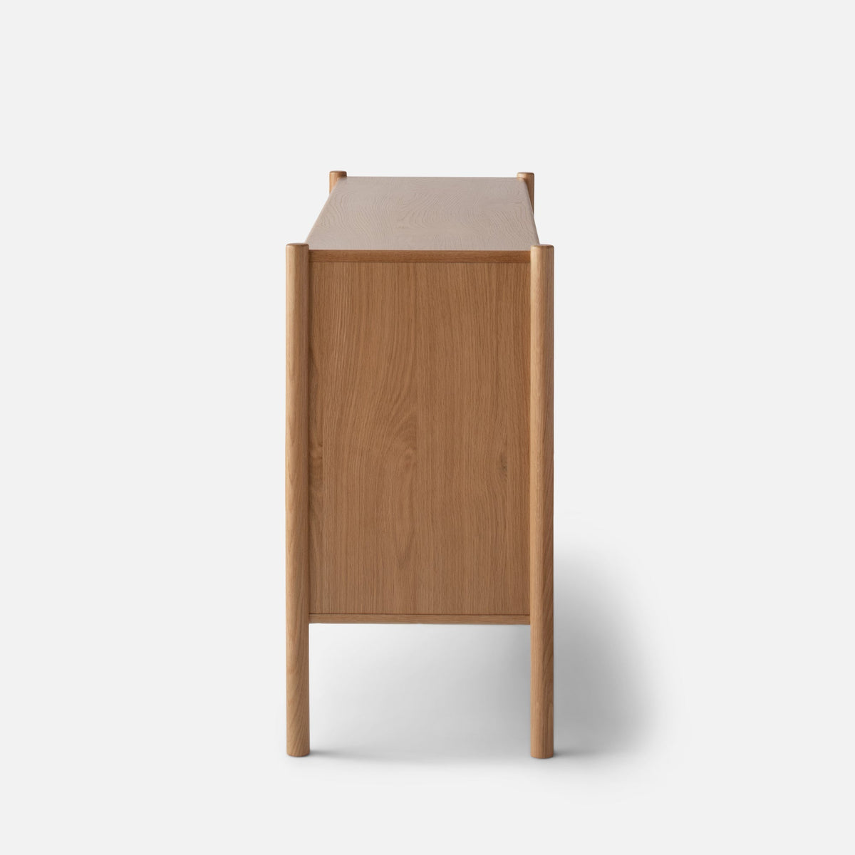 Rear view of Nora 6-Drawer Dresser showcasing oak wood grain and rounded posts against a white background