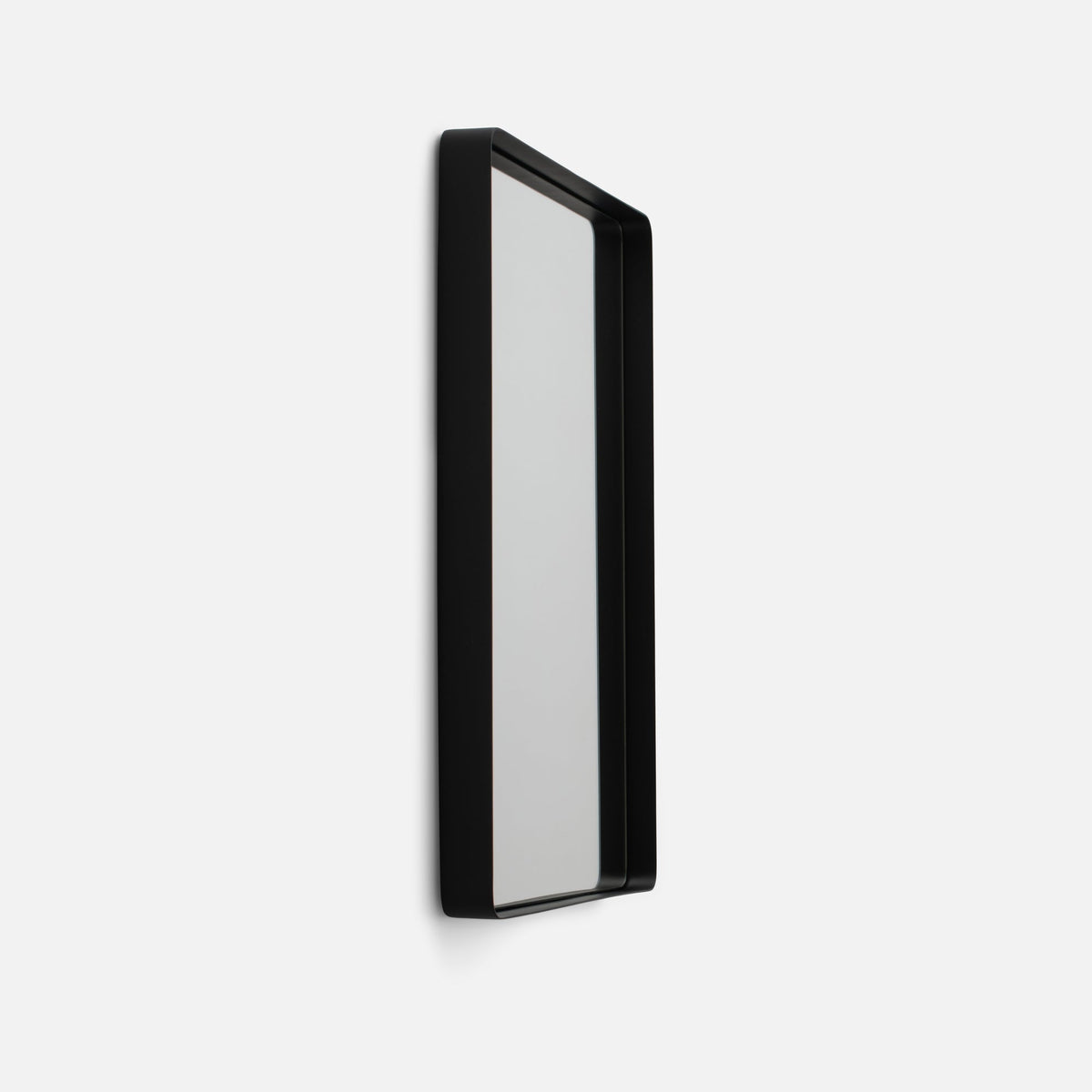 Angled view of Leo Mirror showcasing its black rectangular frame and reflective surface against a white background
