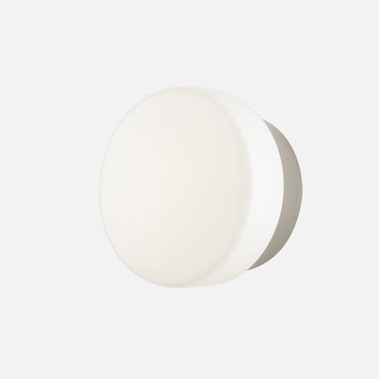 Front view of Beacon Wall Sconce showcasing its round low-profile design with a light gray background