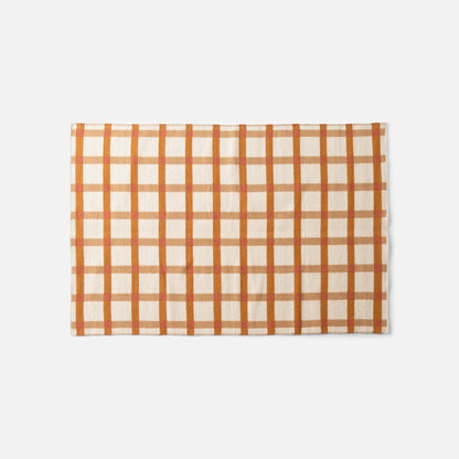 Top edge of Plaid Wool Reversible Rug showcasing orange-and-tan plaid handwoven wool on white background