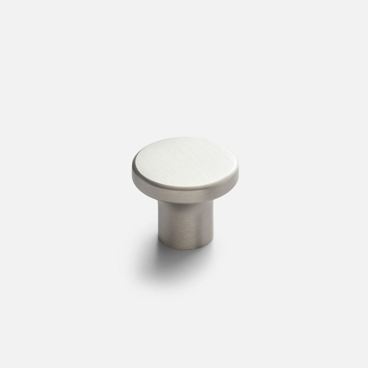 Angled view of the Roland cabinet knob showcasing a round brushed satin nickel face and cylindrical base with a white background