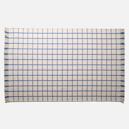 Top-down view of Cotton Grid Flatweave Rug with blue and brown grid pattern and fringed edges on a light background