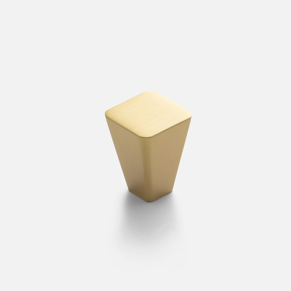 Angled view of Truss Knob showcasing its tapered natural brass body and square top on a white background
