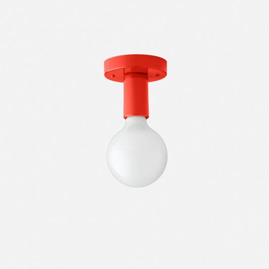 Front view of Cylinder Wall Sconce with a Paprika-Satin cylindrical steel fixture and white round bulb on white background