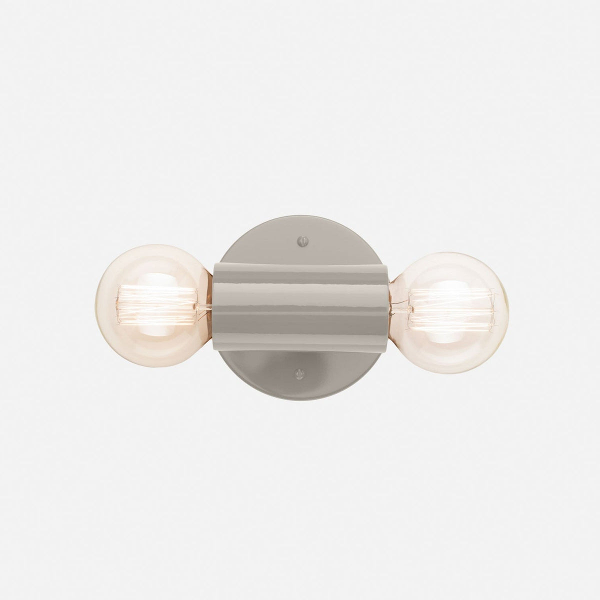 Front view of Cylinder Double Sconce showcasing two globe bulbs and a slender gray fixture on a light background