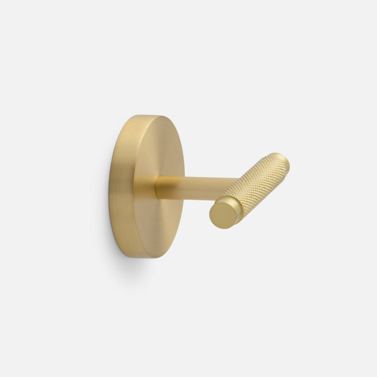 Side view of Knurled Hook showcasing its cross-hatched texture and natural brass finish with a light gray background