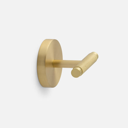 Side view of Knurled Hook showcasing its cross-hatched texture and natural brass finish with a light gray background