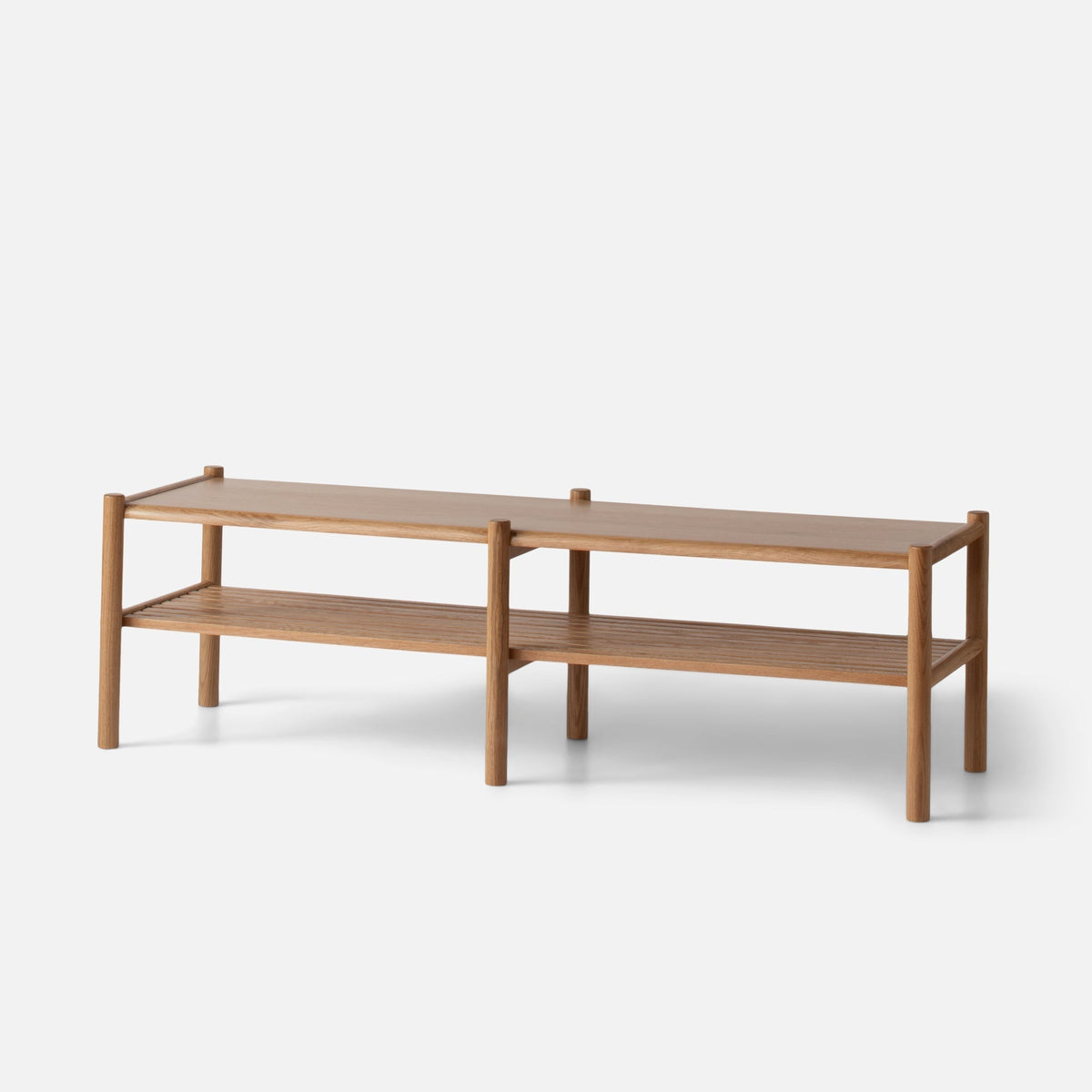Three-quarter view of Nora Storage Bench showcasing oak construction, rounded wood legs, and lower shelf with white background