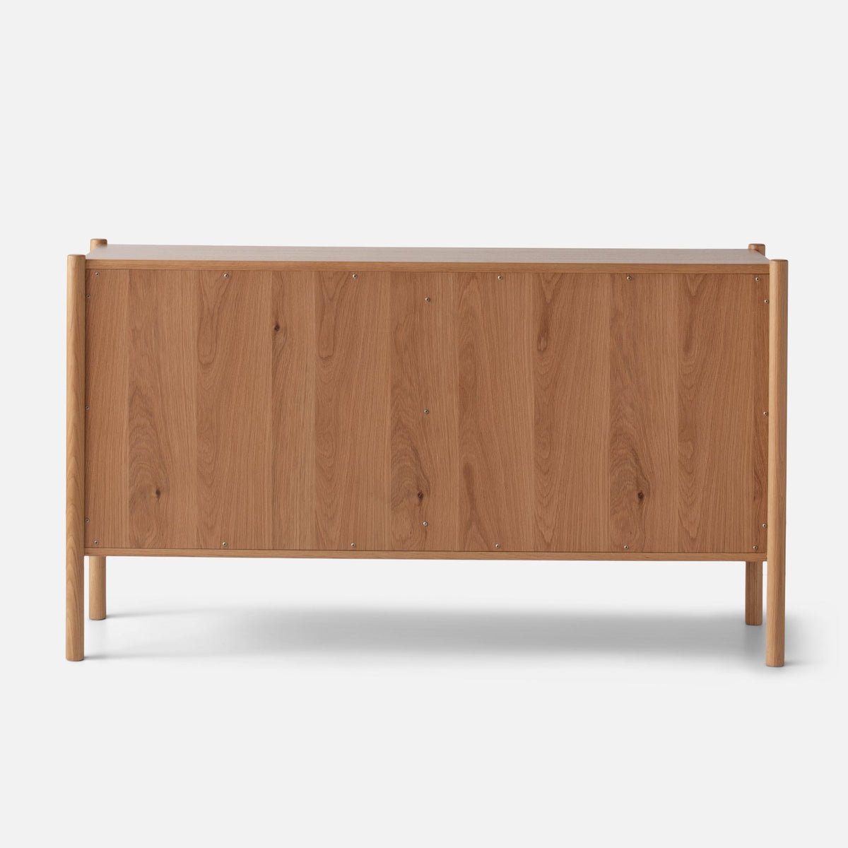 Back view of Nora 6-Drawer Dresser showcasing its oak finish and raised legs against a white background