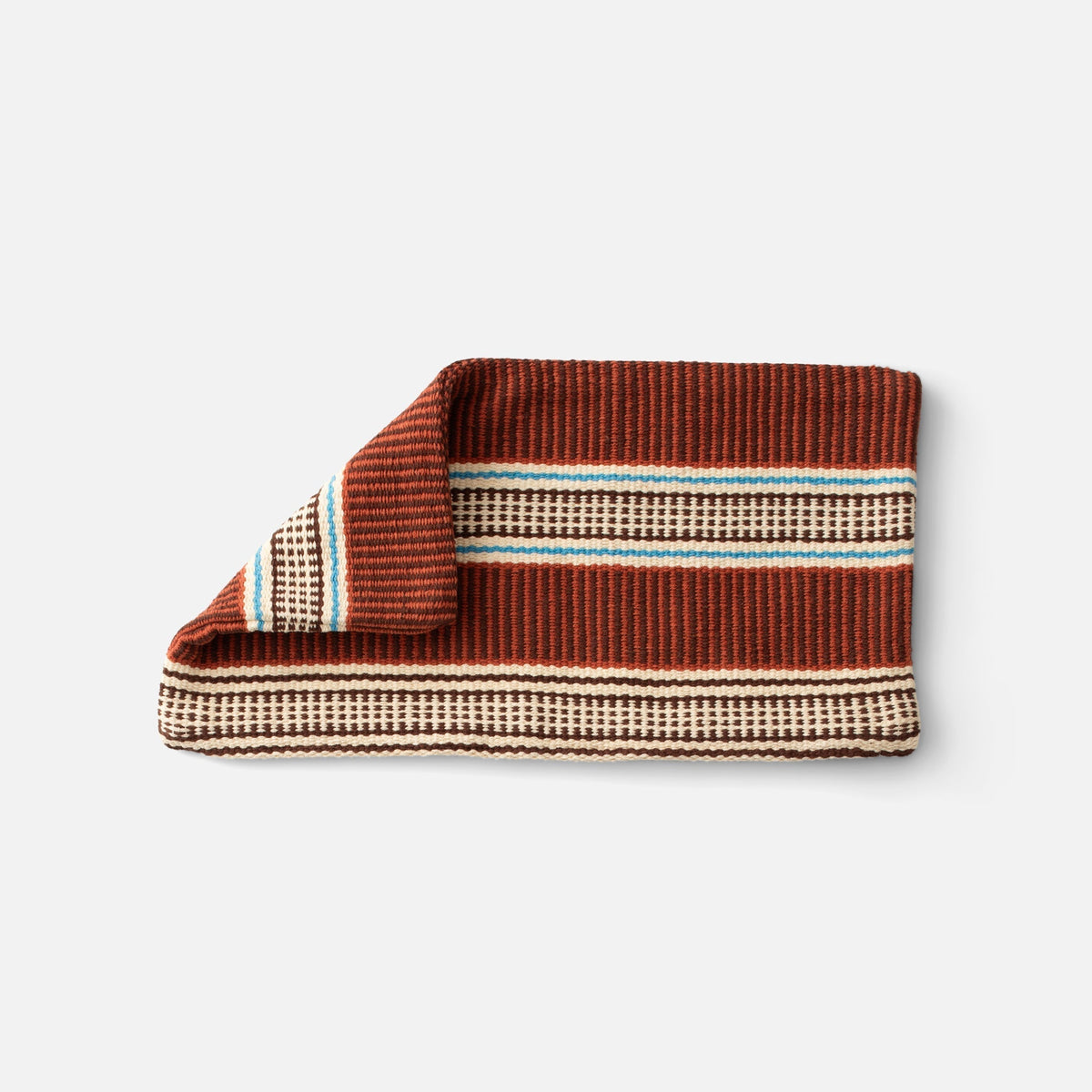 Folded view of Anders Pillow Cover showcasing a brown, cream, and blue striped woven pattern with a white background