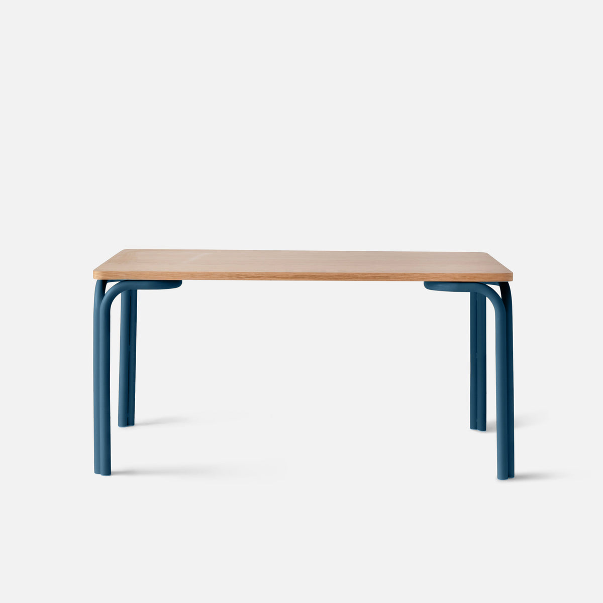Front view of Forma Dining Table showcasing oak veneer top and blue powder-coated steel legs against a white background