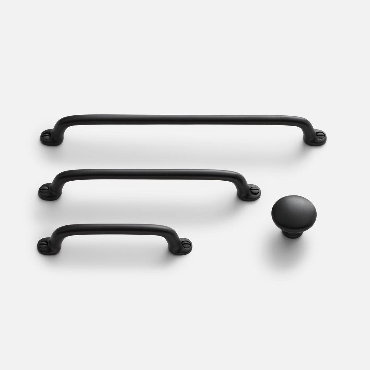 Front view of Belmont Pull hardware in true black, showing three curved pulls and a matching knob on a light background