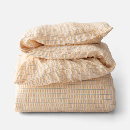 Folded view of Seersucker Check Duvet showcasing yellow and natural cotton seersucker with a check pattern on white