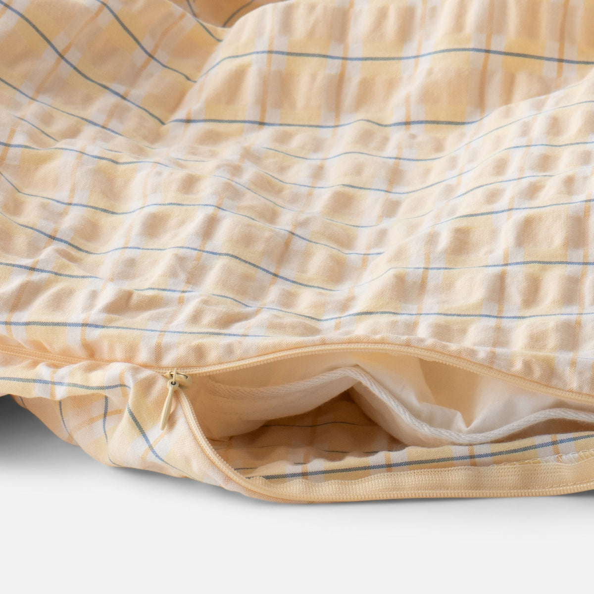 Close-up of Seersucker Check Duvet showcasing yellow check pattern, seersucker texture, and zipper on white background