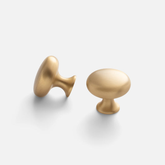 Two views of the Somerset Knob showcasing its egg-shaped solid brass design on a light background
