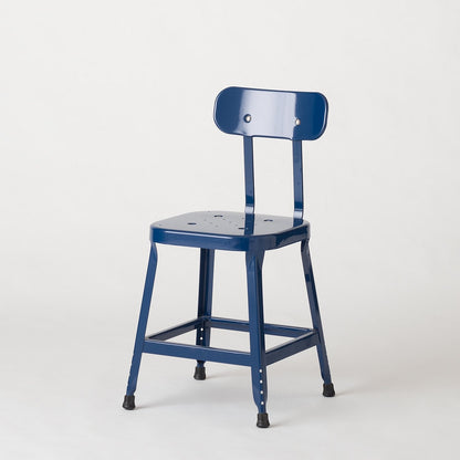 Three-quarter view of Schoolhouse Utility Stool in indigo gloss, showing stamped steel seat and rubber feet on white background