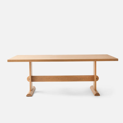 Front view of Darrow Dining Table showcasing solid oak frame and contrasting walnut stretcher on white background