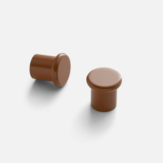 Angled view of two Remy Knobs showcasing solid brass, soft curves, and pared-down silhouettes on a light gray background