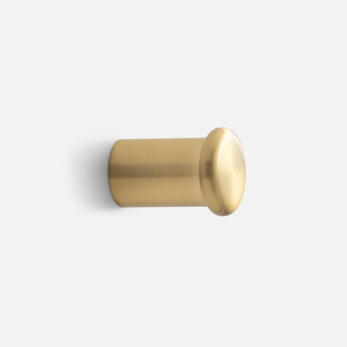 Side view of Remy Single Hook showcasing its cylindrical brass form with a white background