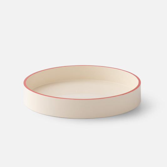 Angled view of Clare V Sonia Tray showcasing its cream finish and coral rim on a white background