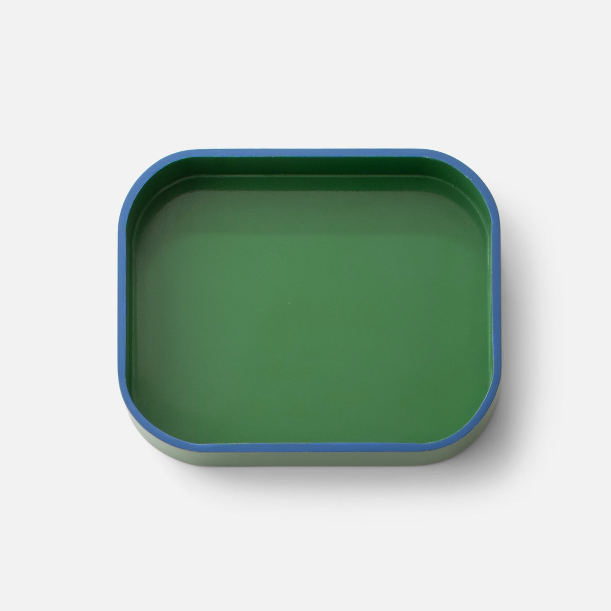 Angled view of Clare V Sonia Tray showcasing its green surface and blue rim with a white background