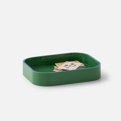Three-quarter view of Clare V Sonia Tray showcasing its green rounded shape and raised edges with cards on white background
