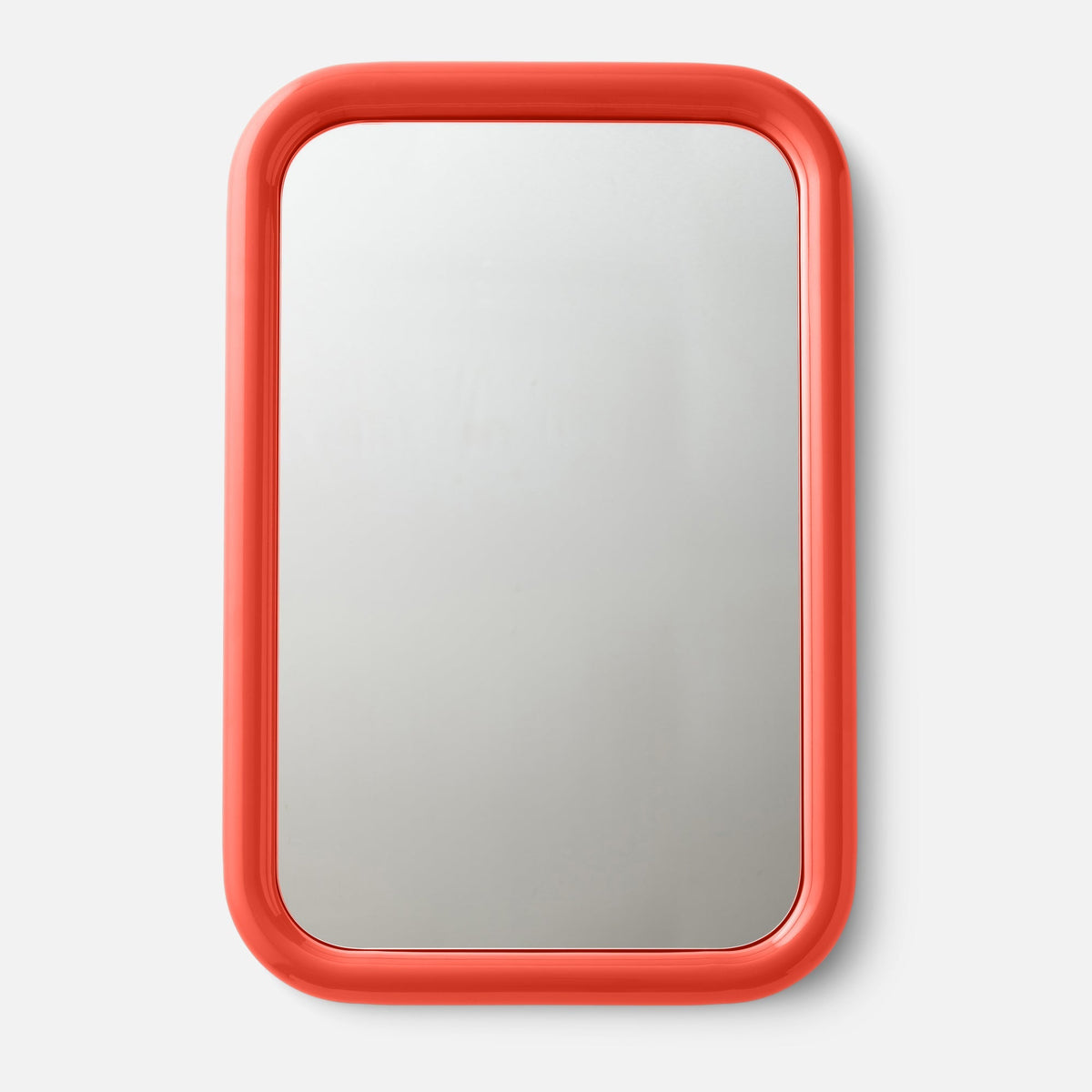 Close-up top view of Forma mirror showcasing glossy coral-red rounded frame against a white background