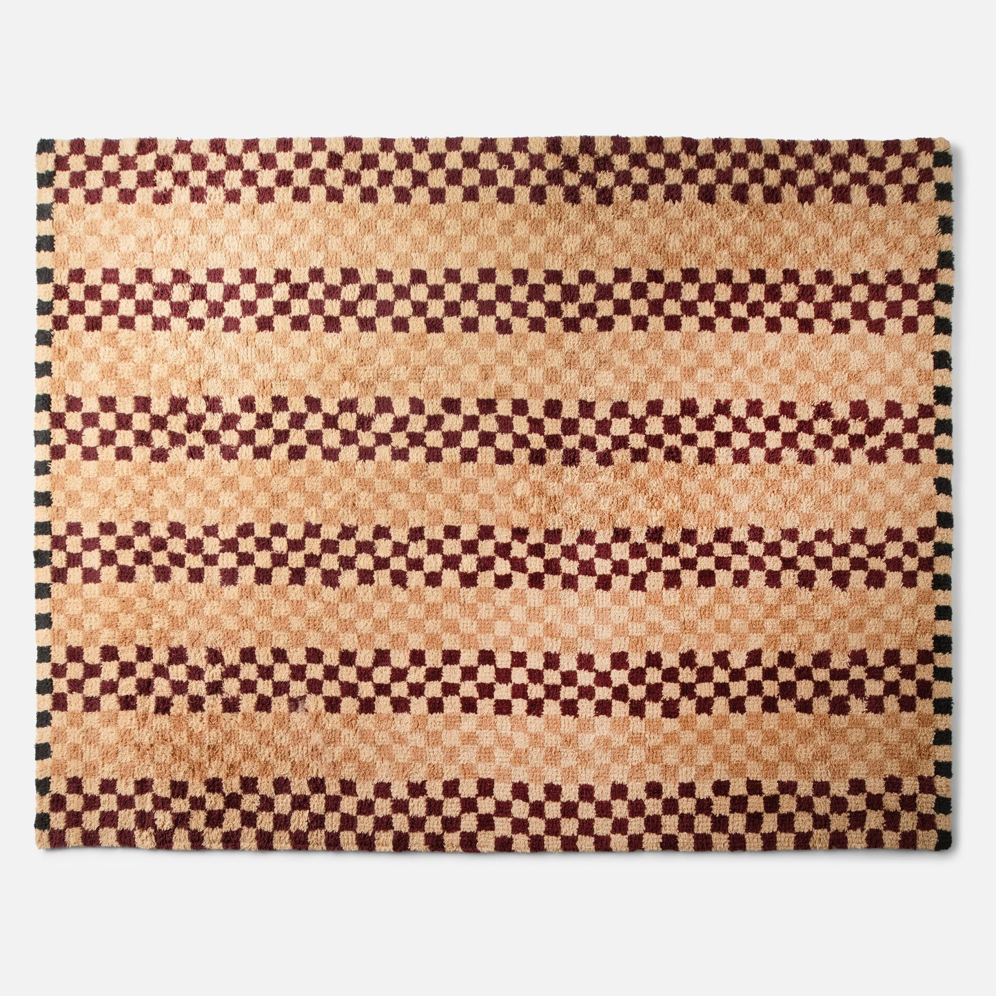 Top view of Felix Shag Wool Rug showcasing butterscotch and raisin checkerboard stripes and shag wool texture on white background