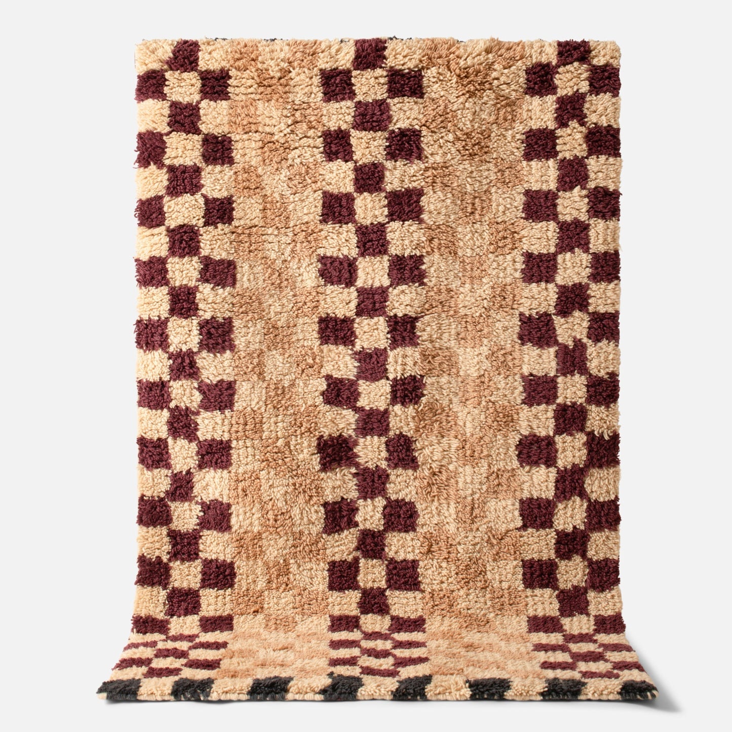 Top close-up of Felix Shag wool rug showing high-pile checkerboard pattern in butterscotch and raisin