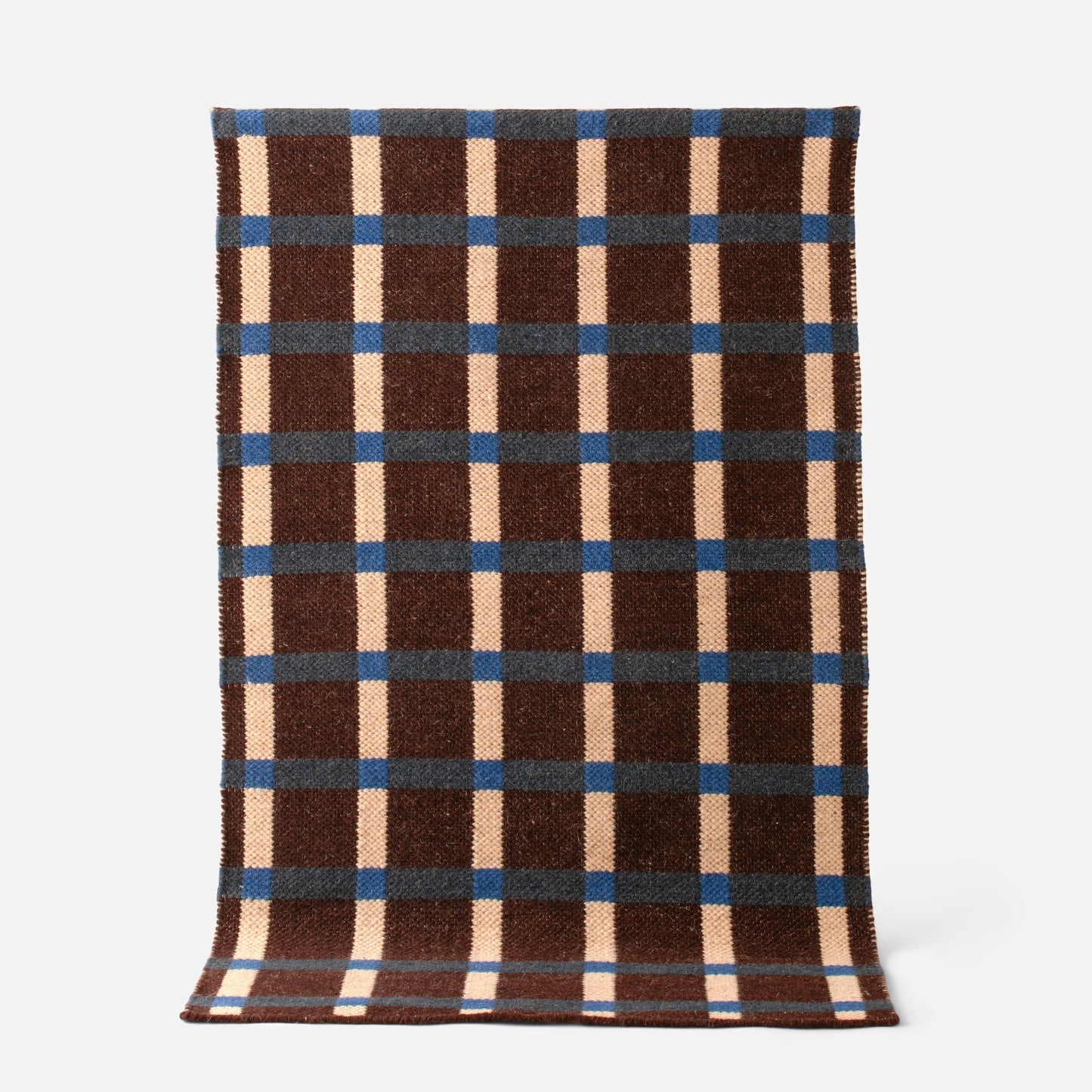 Top view of Plaid Wool Reversible Rug showcasing brown, cream, and blue plaid handwoven wool texture on a light background