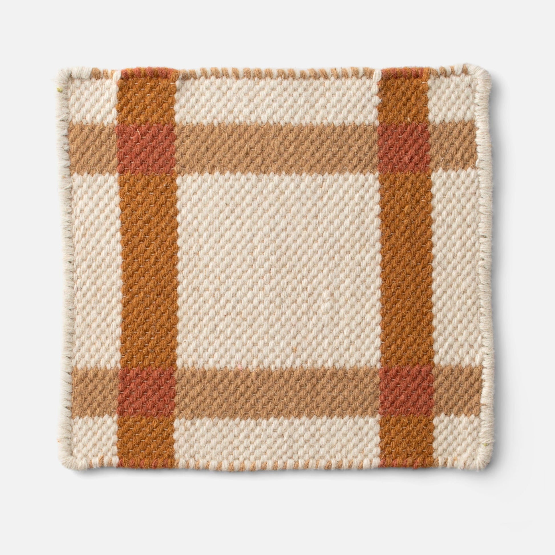 Close up of Plaid Wool Reversible Rug corner showcasing handwoven wool texture and beige and rust plaid on white background