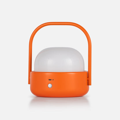 Front view of Cooper Table Lamp showcasing orange housing, carry handle, and white diffuser against a light background