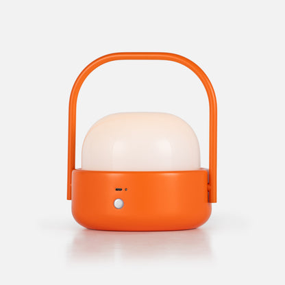 Front view of Cooper Table Lamp showcasing an orange body, white dome shade, and arch handle against a white background