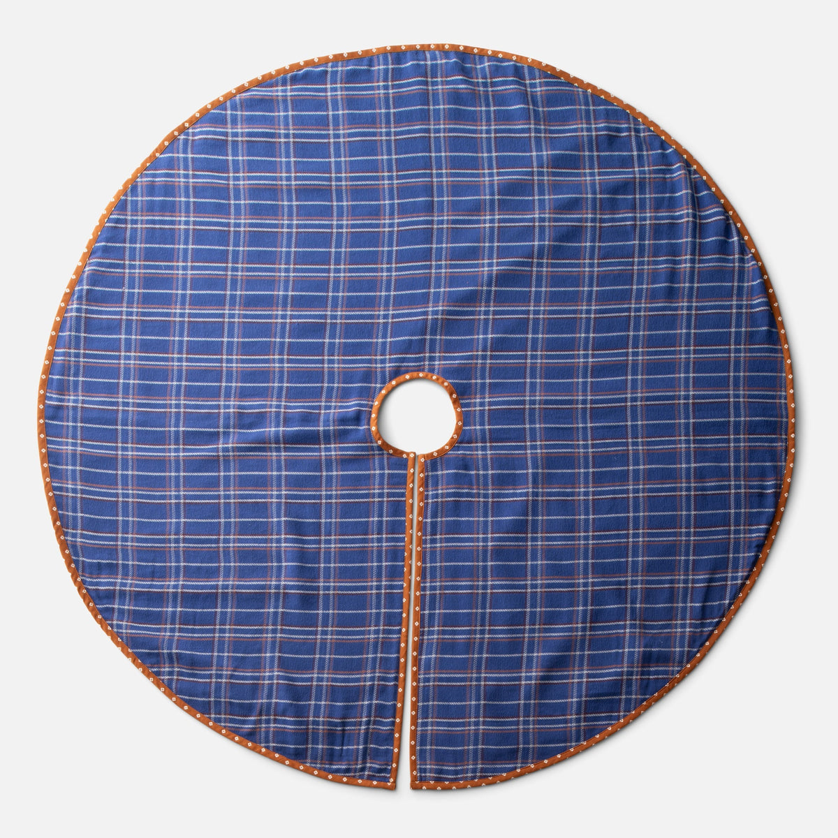 Top view of Haberdasher’s Tree Skirt showcasing cobalt plaid cotton, brown patterned trim, and center opening on white