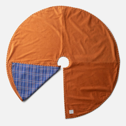 Top view of Haberdasher’s Tree Skirt showcasing rust corduroy, blue plaid, and patterned trim with a light gray background