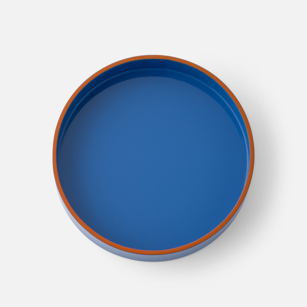 Top view of Clare V Sonia Tray showcasing its blue surface and orange rim against a white background