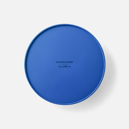 Top view of blue Clare V Sonia Tray showcasing its raised rim and centered Clare V branding on a light gray background