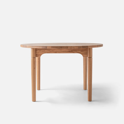 Front view of Willard Dining Table showcasing softly rounded oak tabletop and tapered legs with a white background