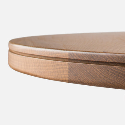 Close-up of Willard Dining Table showcasing softly rounded solid oak edge with a white background