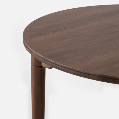 Close-up of Willard Dining Table showcasing rounded edge, classic apron, and tapered leg against a white background