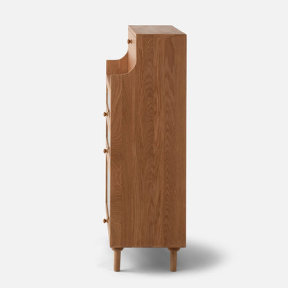 Side view of Peggy Cabinet showcasing wood grain, multiple drawer pulls, and tapered legs against a white background