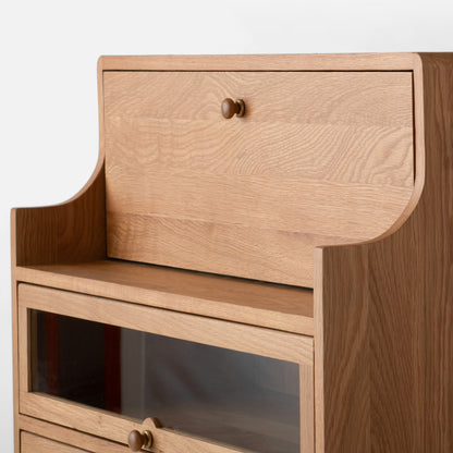 Close-up view of Peggy Cabinet showcasing wood grain, rounded edges, and drawer knobs against a light background