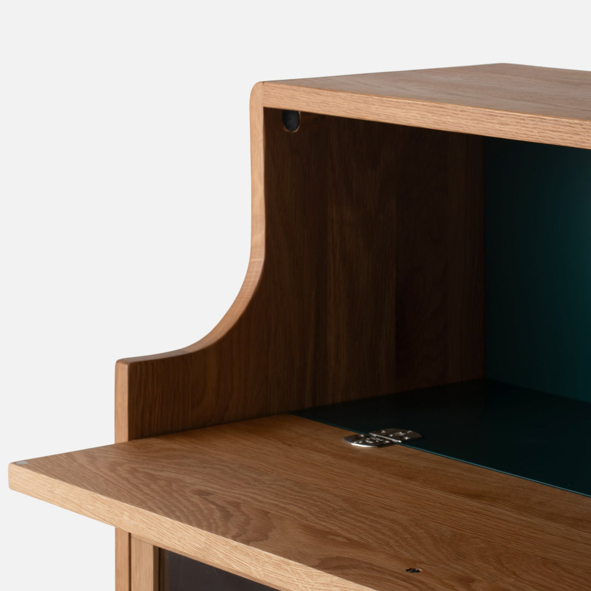 Close-up of Peggy Cabinet showcasing its open door, wood grain, and teal interior against a white background