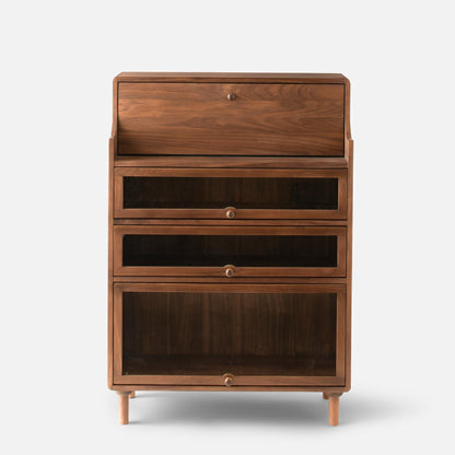 Front view of Peggy Cabinet showcasing a warm wood finish, three glass-front compartments, and tapered legs