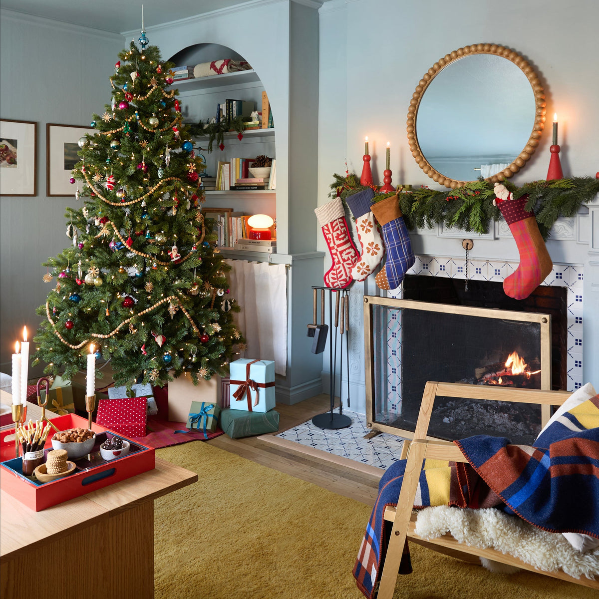 Festive living room with a decorated Christmas tree, fireplace, and red Swiss Scallop Stocking on the mantel