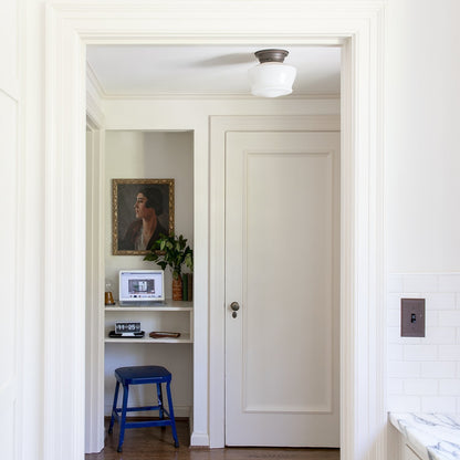 Front three-quarter view of Schoolhouse Utility Stool showcasing indigo gloss steel in a home hallway