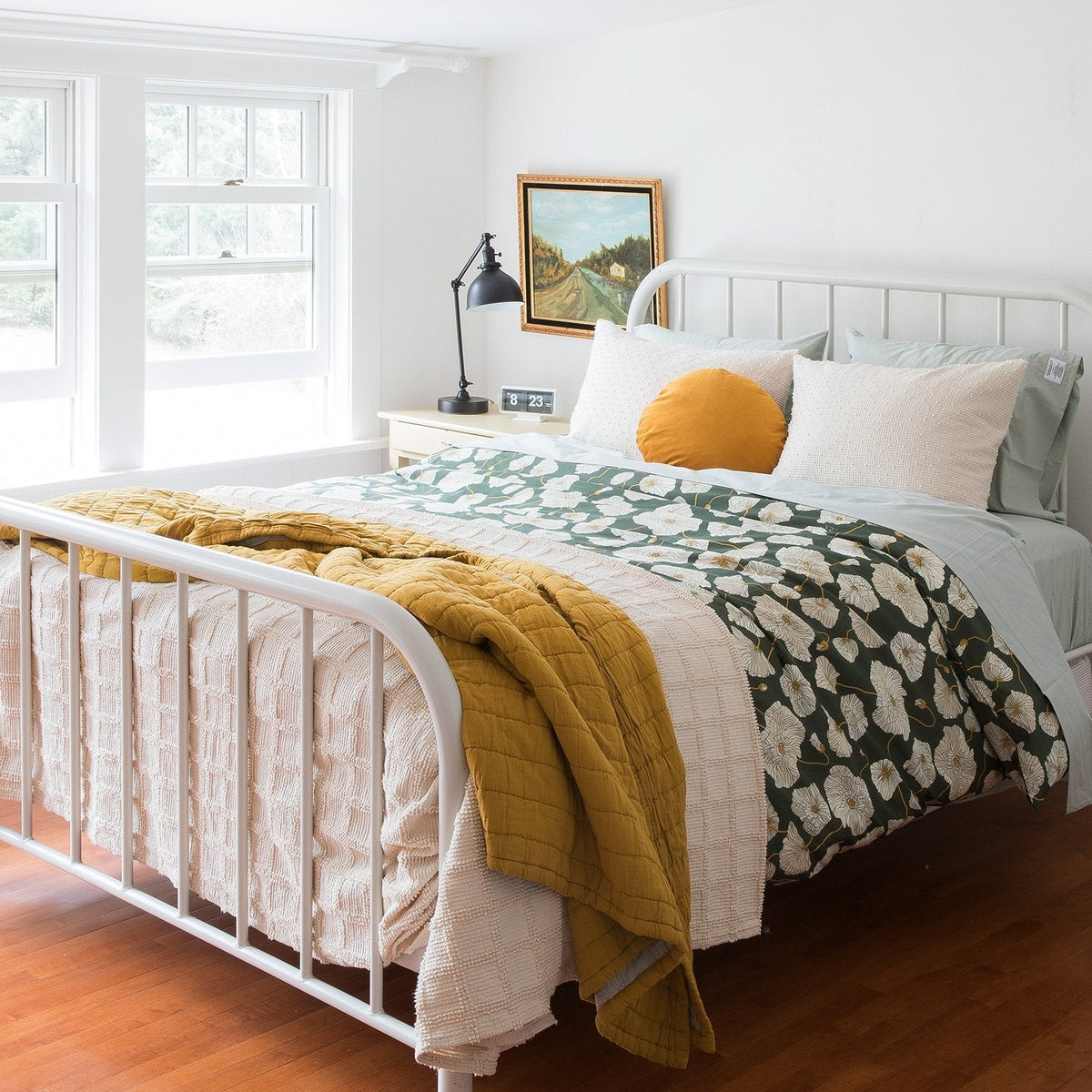 Angled view of Channeled Cotton Quilt showcasing mustard yellow quilted channels on a bed in a bright bedroom