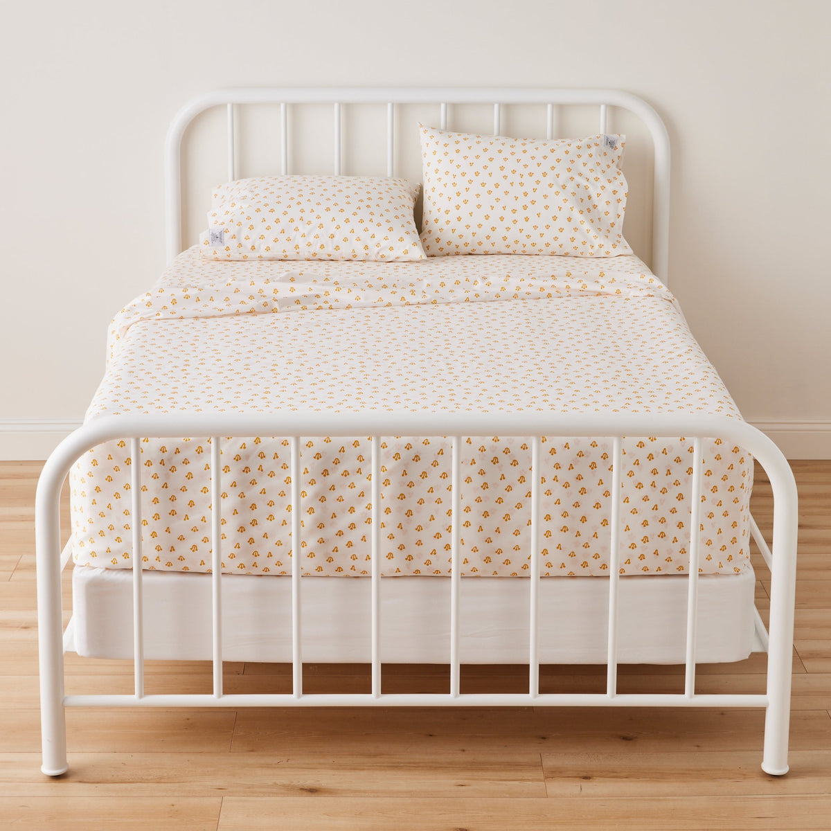 Front view of Thistle Sheet Set showcasing hand-drawn thistle pattern on a bed with a white metal frame