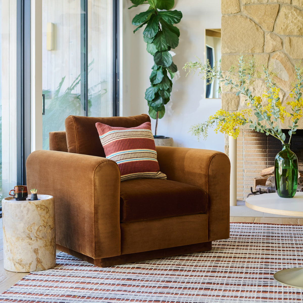 Striped Anders pillow cover displayed on a brown armchair in a bright living room
